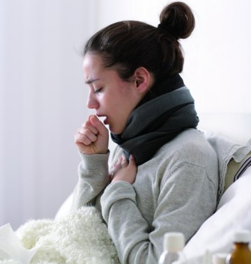 Kranke Frau liegt im Bett
