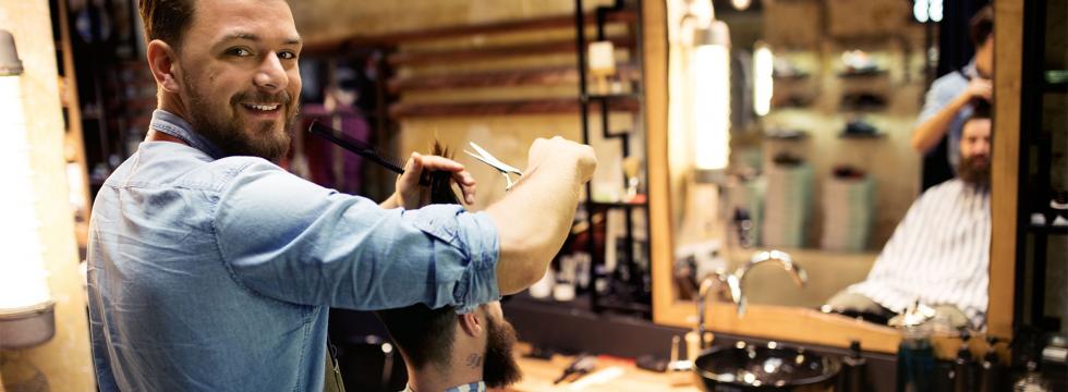 Friseur schneidet dem Klienten in einem Friseursalon die Haare