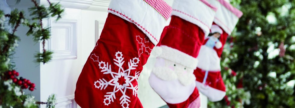 Weihnachtsstiefel aus Stoff hängt über einem Kamin