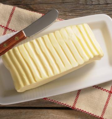 Eine Portion Butter auf einem kleinen Teller mit Butter messer und Serviertuch