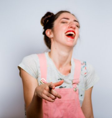 Frau lachend mit Fingerzeig