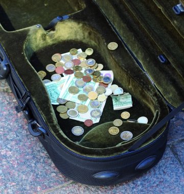 Geld im Koffer eines Straßenmusikers