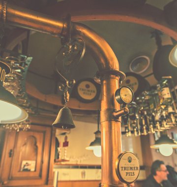 Die Wand un d Decke einer Bar hinter einem altertümlichen Zapfhahn