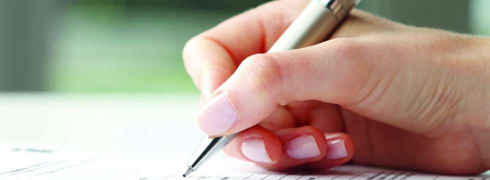 Rechtschreibung im Deutschen - Hand mit Stift