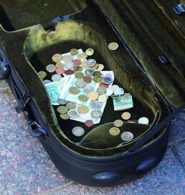 Geld im Koffer eines Straßenmusikers