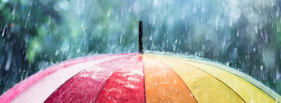Bunter Regenschirm auf den Regentropfen fallen