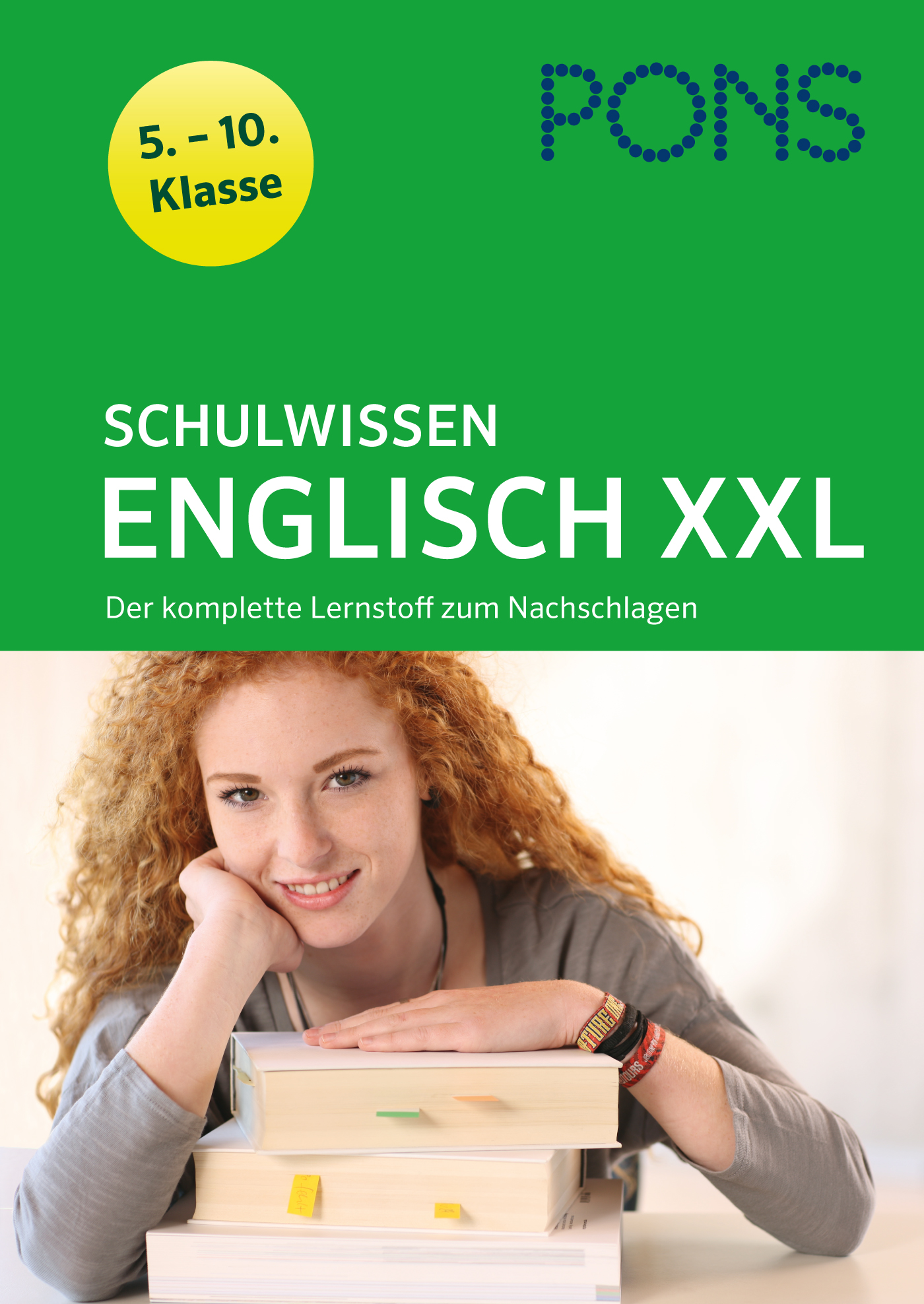 Eine junge Frau mit gelockten roten Haaren lehnt an einem Stapel Bücher und lächelt. Auf dem Buchdeckel steht Schulwissen Englisch XXL für die Klassen 5-10 von PONS.